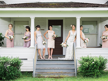 Maureen and her beautiful bridesmaids stand outside of a historical building on the grounds of the Greenmead Historical Village in Farmington Hills, Michigan.