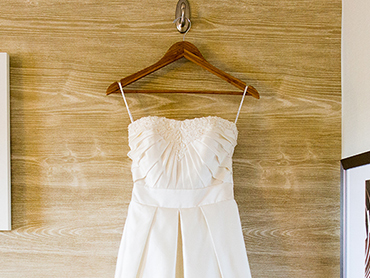 Ashleys short wedding dress hangs in her bridal suite before her Ann Arbor botanical garden wedding