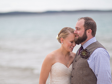 Heather & Josh cuddle on the beach of Lake Michigan at the Homestead Resort in Glen Arbor.