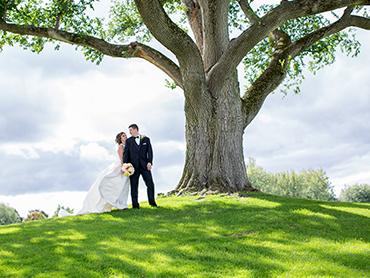 Katie & Ryan share a moment under a huge oak tree during their Bloomfield Hills wedding
