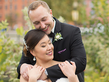 Gabby and Aaron hug in the gardens of downtown Kalamazoo, Michigan on their wedding day.