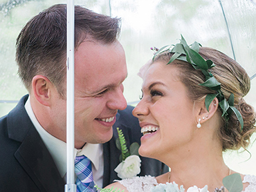 Dave & Maureen hide under an umbrella from the rain on their Michigan Wedding Day