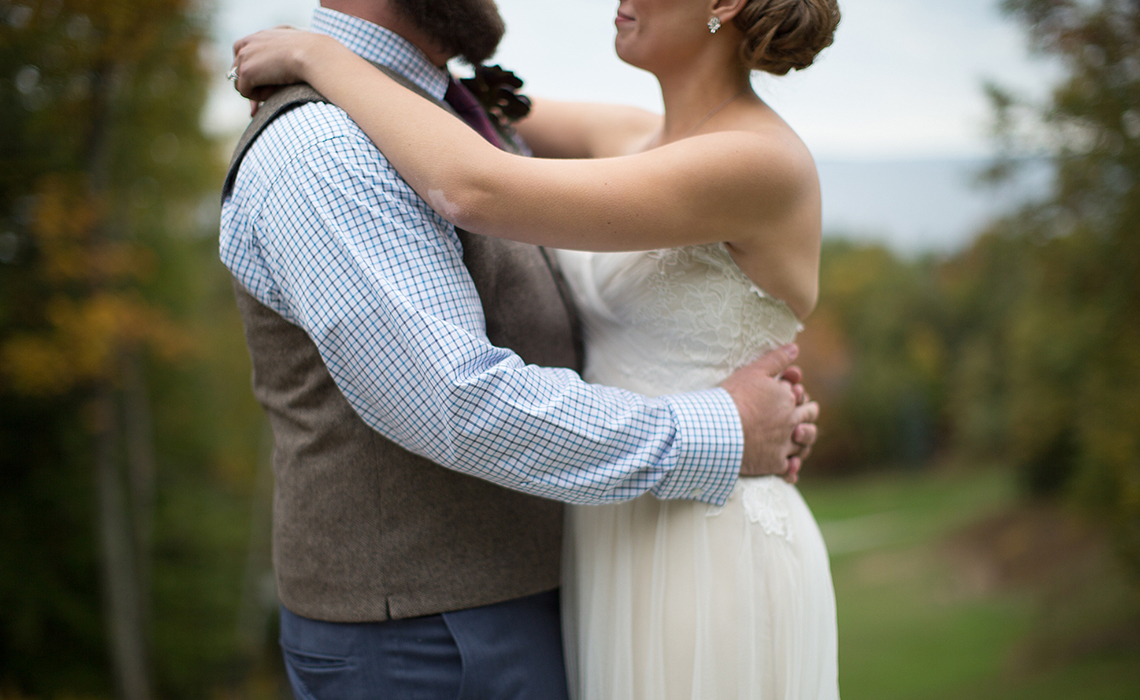 The bride and groom stand on the shores of Lake Michigan at the Homestead Resort