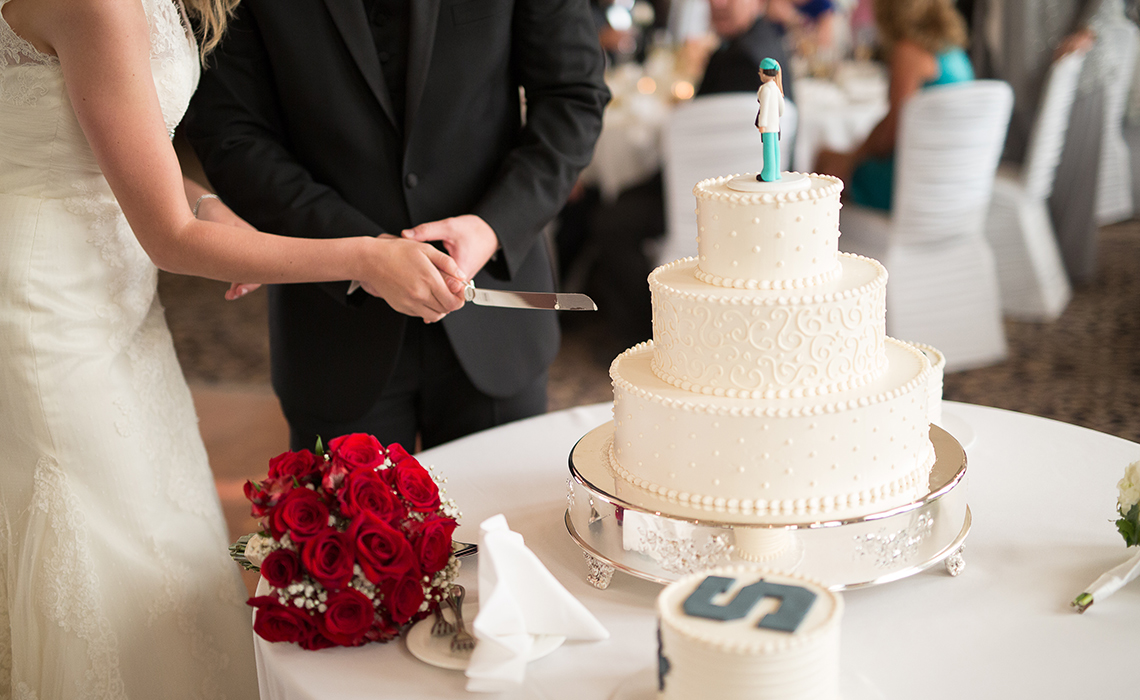 Cutting their beautiful personalized wedding cakes at their wedding reception in Plymouth, Michigan